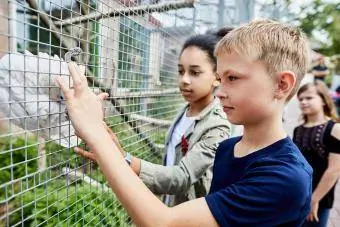 Niño y niña con loro en un aviario