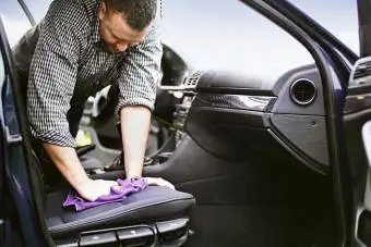 Un uomo pulisce la tappezzeria della sua auto