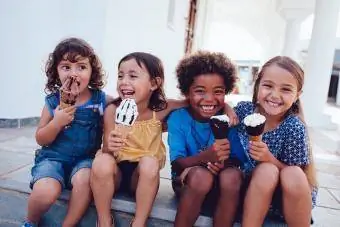 მხიარული ბავშვების ჯგუფი ზაფხულში ნაყინს მიირთმევს