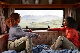 Karavan minibüsünde pencereden dışarı bakan iki bayan arkadaş