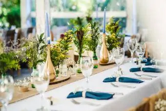 decoração de mesa elegante com tema azul-petróleo e buquê de flores