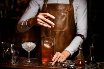Barman roert alcoholische drank met een lepel