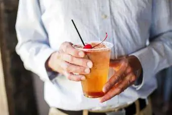 Die Hände eines Mannes h alten einen Cocktail