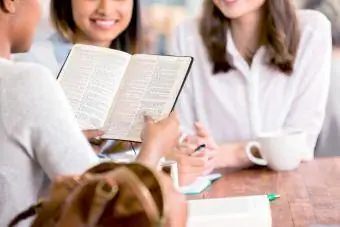 Birlikte İncil okuyan ve bilgi oyunu oynayan insanlar