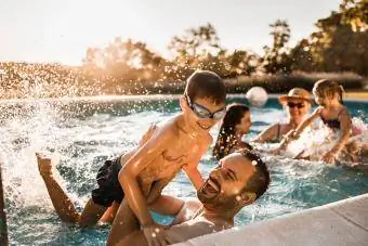 Linksmi tėvas ir sūnus linksminasi baseine