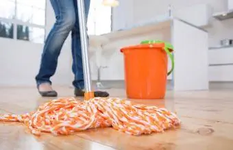 Kadın mutfağın zeminini siliyor