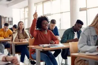 student zvedne ruku pro debatu ve třídě