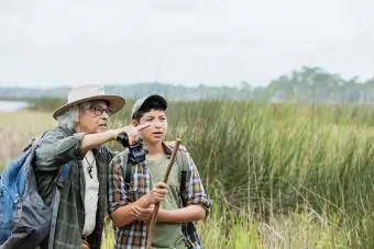 мальчик в походе с дедушкой, наблюдает за птицами