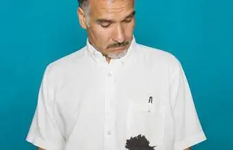 Vyras žiūri į rašalo dėmę ant marškinių