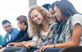 dospívající dívky ve třídě při pohledu na mobilní telefon