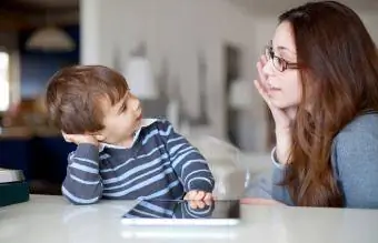 Kleine jongen praat met zijn moeder