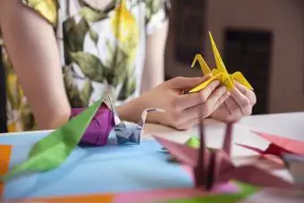 Teenager vyrába origami zo žltého papiera