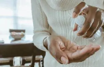 Une femme utilise un désinfectant pour les mains