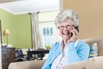 Pagyvenusi moteris telefonu atrodo laiminga