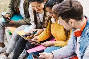Học sinh tuổi teen vui vẻ sử dụng điện thoại di động