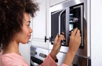 Mujer ajustando la temperatura del horno microondas