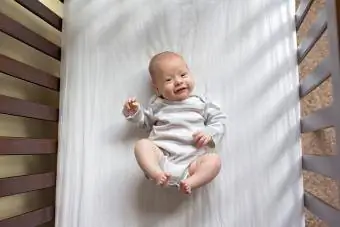 Potret bayi laki-laki di tempat tidur bayi di rumah