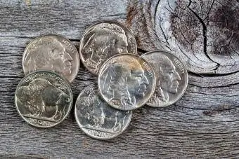 Rares monedes de níquel amb cap de búfal sobre fusta rústica