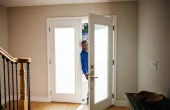 vyras prie savo namo durų