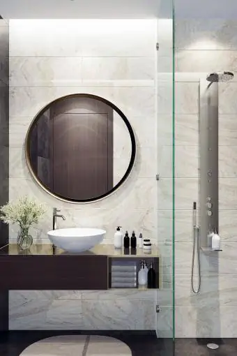 Μικρό πολυτελές μινιμαλιστικό μπάνιο με στρογγυλό καθρέφτη