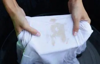 Ženska pere umazano majico s kratkimi rokavi