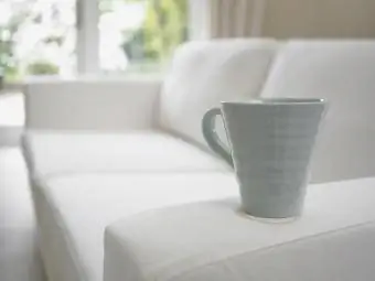 kavos puodelis ant sofos