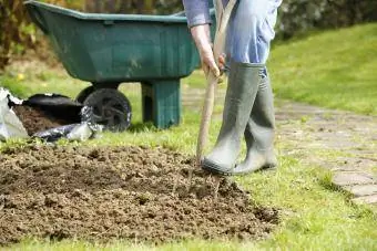 Tuinman die een stukje in de tuin aflegt