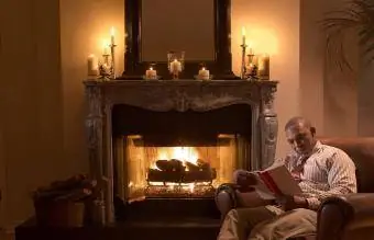 Hombre maduro leyendo junto al fuego