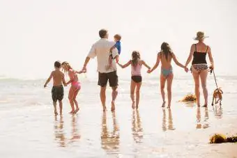Familia de siete camina por la playa.