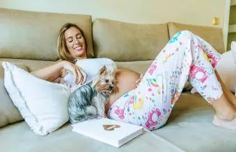 Wanita hamil dan anjing berbaring