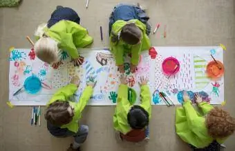 Vorschulkinder verwenden Fingerfarben auf Plakaten