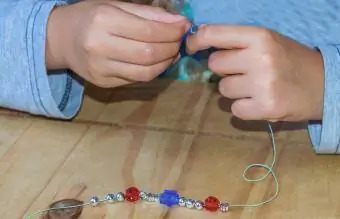 gadis membuat gelang manik-manik