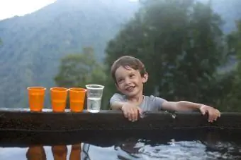 Ребенок играет с чашками с водой