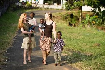 Två unga missionärer med afrikanska barn