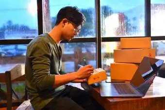 Teenager packt Kartons zum Versenden