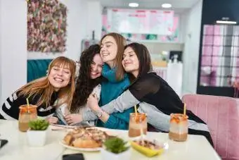 4 garotas se abraçando enquanto tomam um brunch