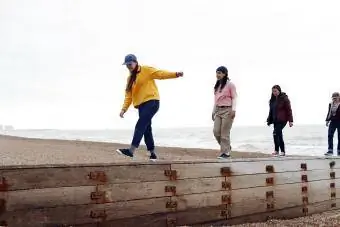 4 gadis berjalan di atas dinding di pantai