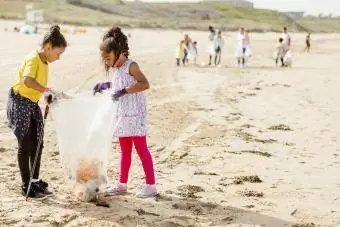 genç kızlar sahilde çöp topluyor