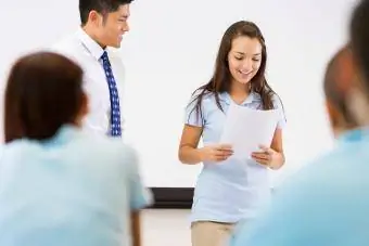 Menina sorrindo e falando na frente da turma