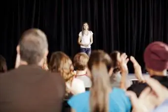 मंच पर एक किशोर लड़की के लिए तालियां बजाते दर्शक