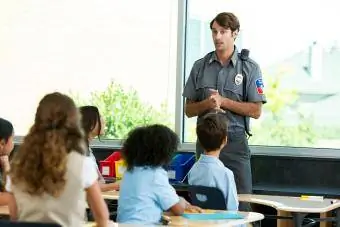 Oficeri i policisë duke folur me fëmijët e shkollës