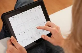 donna che utilizza il calendario sulla tavoletta digitale