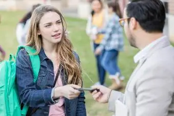 Guru mengambil telefon bimbit daripada pelajar