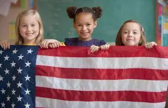 תלמידים בכיתה אוחזים בדגל אמריקאי