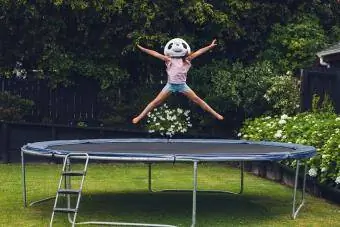 Mädchen mit Panda-Maske auf Trampolin