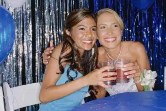 dua remaja perempuan memegang gelas pukulan