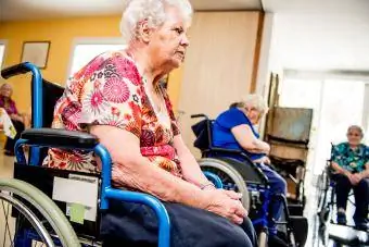 Personas mayores en sillas de ruedas en una residencia de ancianos