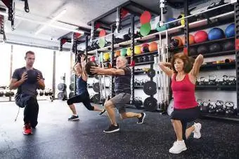 Senioren trainieren mit Personal Trainer im Fitnessstudio