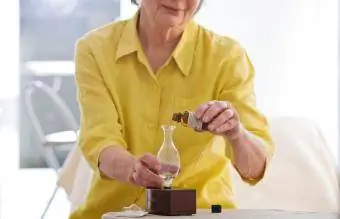 Femme âgée utilisant un diffuseur d'huiles essentielles