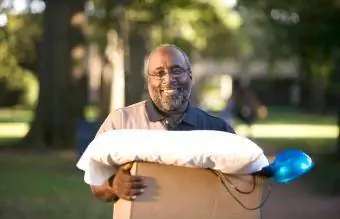 رجل مبتسم يحمل صندوقًا